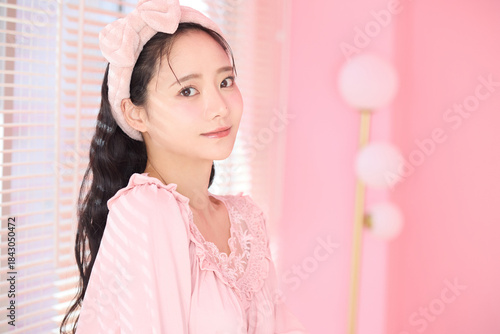 窓際に立つかわいい女性の美容ポートレート