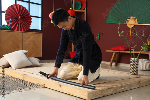 Young Asian man with katana...