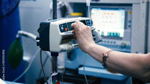 Fotografía Medical professional adjusting infusion pump in a clinical setting, showcasing a