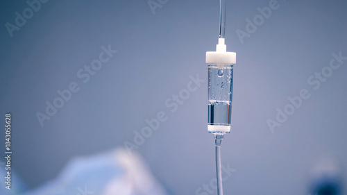 Bild auf Leinwand Medical IV drip bag suspended in a clinical setting, showcasing clear fluid and