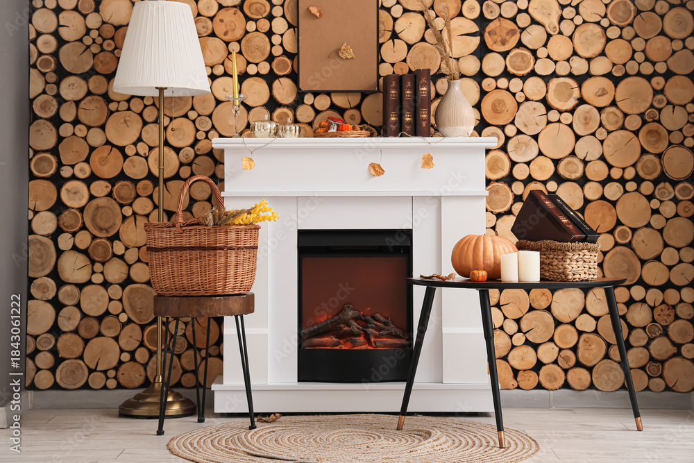 Obraz premium Stylish interior of living room with fireplace, coffee table, basket and lamp