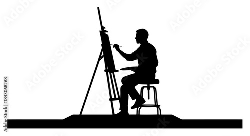 Silhouette of an artist sitting on a stool painting on a canvas