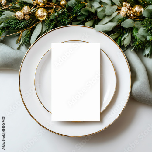 Elegant blank menu mockup placed on a white plate with gold trim, styled with green foliage for a festive table setting