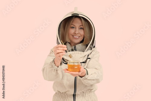 Female beekeeper with jar o...