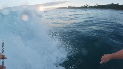 POV. Surfer catching wave in Atlantic ocean during sunrise.