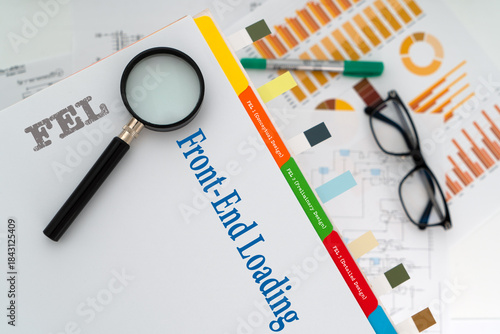 FEL front end loading engineering document with charts magnifying glass and office supplies