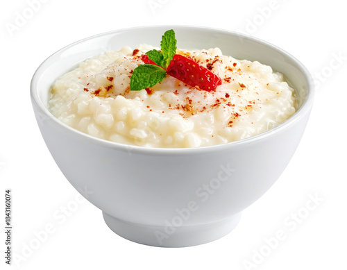 Creamy rice pudding in a white bowl, garnished with strawberry and mint