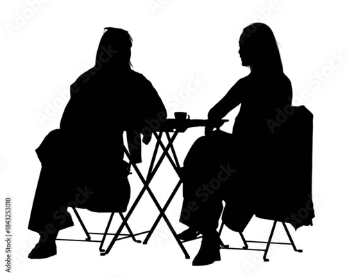 Two young women enjoying coffee together at an outdoor cafe.