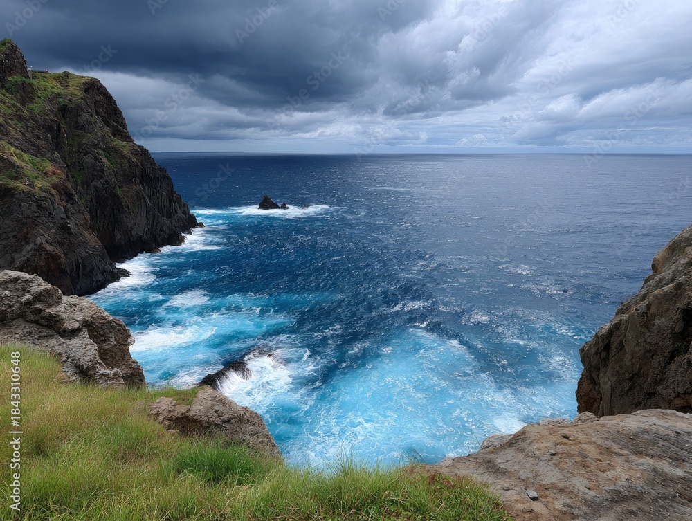 Fototapeta premium Cliffside view with turquoise churning water under a moody clouded sky