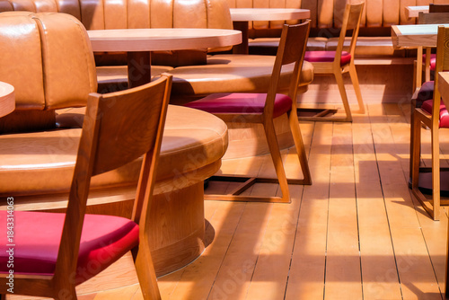 Wooden chairs and tables in a row in the interior of a restaurant