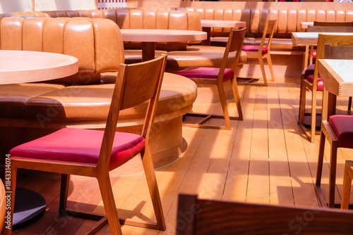 Wooden chairs and tables in a row in the interior of a restaurant