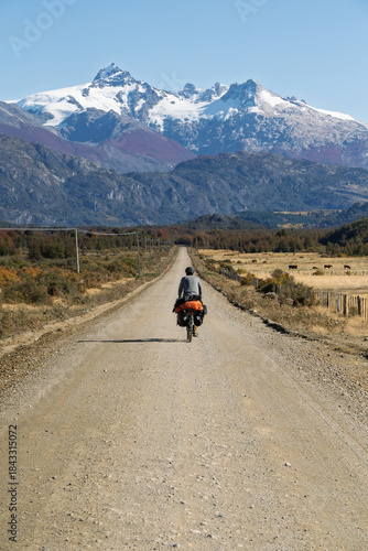 Cyclist cycle touring long straight gravel road on Carretera Austral, Chile