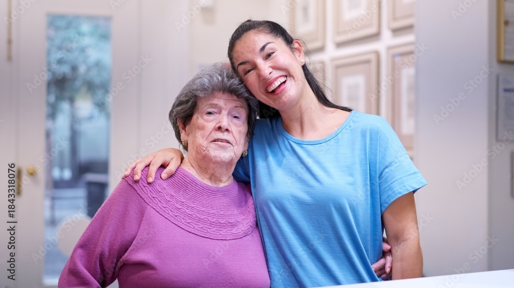 Fototapeta premium Granddaughter embracing grandmother, showing family support and care