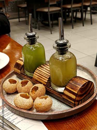 Indian snack pani puri placed on a wooden table in a restaurant