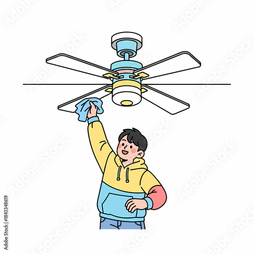 Young man cleaning a ceiling fan with a cloth, promoting home hygiene and a clean living space