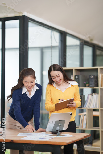 Asian businesswoman at work using laptop talking and consulting in office	