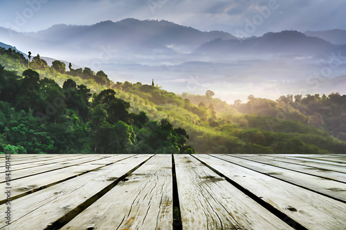 Serene mountain landscape with wooden deck at sunrise