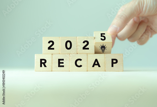 2025 Recap economy, business, financial concept. Business planning in 2026. RECAP text on wooden blocks and hand flipping of 2025 to strategic planning and idea icon on wooden blocks.