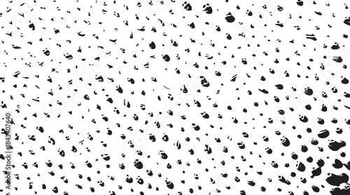Textured background of scattered black dots and irregular shapes in varying sizes on a white surface