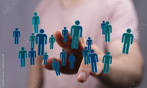 Photos Hand reaching towards 3D figures representing people and networks