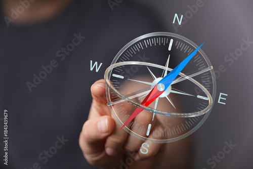 Hand holding a compass for ...