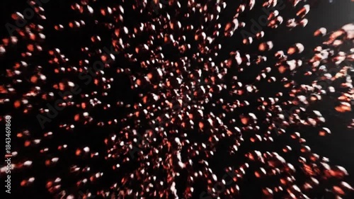 Dramatic close up of amber liquid splashing upwards creating many small droplets against a dark background