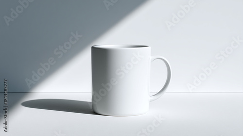Modern White Ceramic Coffee Mug with Dramatic Shadow and Natural Light Stripe on White Surface
