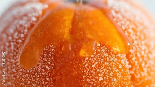 Close Up View of Orange Citrus Fruit Covered in Ice Crystals with Droplets Forming a Textured Surface