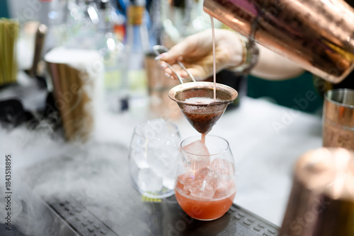 Pink Cocktail Poured Through Strainer with Vapor Effect