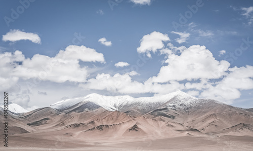 Landscape in the Pamir Mountains of Tajikistan with snow, glaciers, and cliffs, a panorama of mountains in cloudy weather for the background, nature in the Tien Shan highlands, landscape background