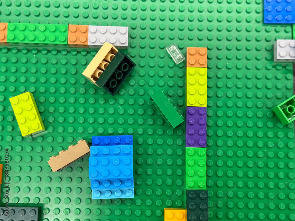 Obraz premium Colorful lego bricks on green base plate