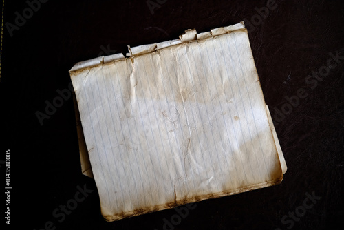 Vintage cinematic shot of an old textured notebook with handwritten notes. Antique paper aesthetic, nostalgic and atmospheric background for historical or creative projects