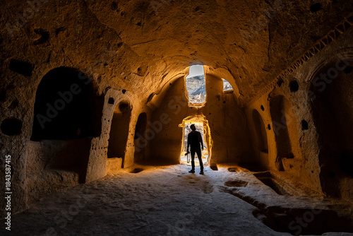 Tablou pe pânză Zelve Open Air Museum, Cappadocia, a man explores the interior of a carved cave church shaped within volcanic rock