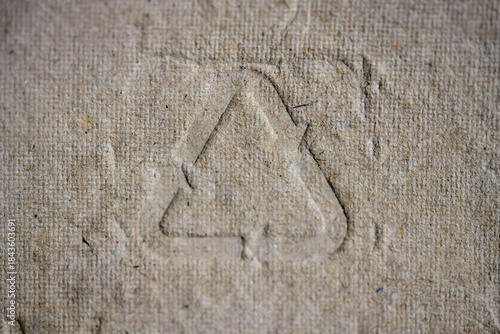 Natural brown paper pulp packaging texture featuring the universal recycling code 21, symbolizing environmental consciousness, sustainability, and responsible consumption.