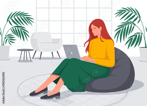 A woman sits comfortably in a stylish bean bag chair, typing on her laptop while surrounded by an aesthetically pleasing modern interior with green plants.