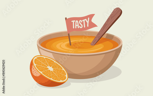 A charming bowl of vibrant orange soup is set against a pale background, complete with a wooden spoon and a small flag proclaiming its taste, appealing to culinary delights.