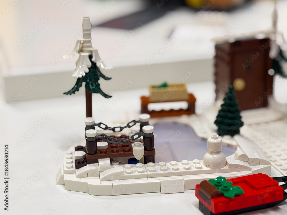 Fototapeta premium Winter-themed lego scene with snowman and frozen pond