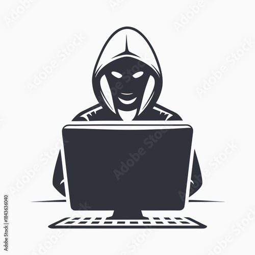 Person in dark hooded top is seated before a computer screen and keyboard