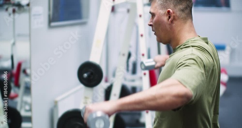 Dumbbell raises for the deltoid muscles. Deltoid workout. Caucasian man performs dumbbell raises, focusing on strengthening his deltoid muscles.