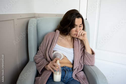 Tired mother pumping breast milk suffering postpartum depression