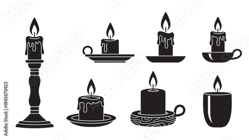 Black Candles Burning in Various Holders on White Background