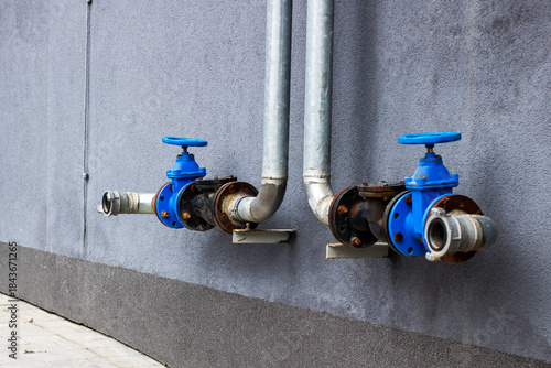 Industrial exterior scene featuring aged water valves and weathered infrastructure components