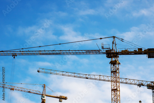 Rusty steel towers create intricate patterns against clear morning skies in city