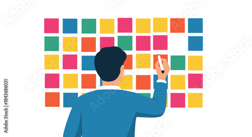 Man from behind organizing a project or schedule by writing on a large board with a grid of colorful sticky notes.