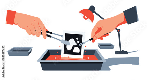 Hands carefully developing a black and white photograph in a darkroom, using tongs to dip the print into a chemical bath under a red safelight.