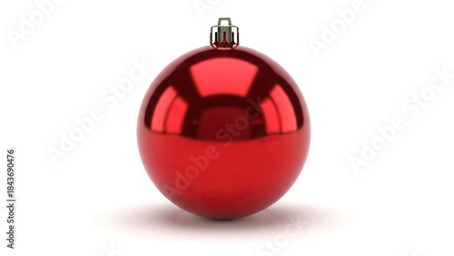 Shiny red Christmas ornament with silver cap casting a soft shadow on a white surface