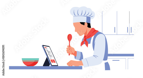 Professional chef in uniform learning a new recipe from a digital tablet in a modern kitchen, tasting food from a red spoon.