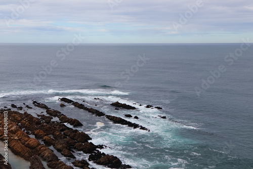 Mossel Bay Point Rocks On Calm Overcast Day Pointing Towards An Open Ocean Horizon, South Africa