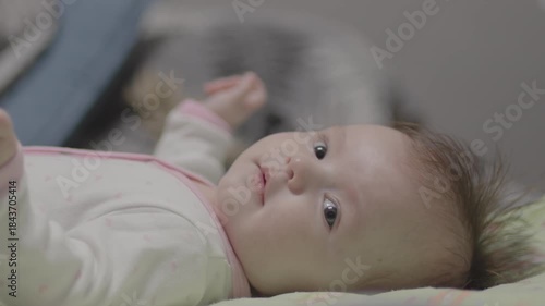 Adorable newborn baby girl lying in cot