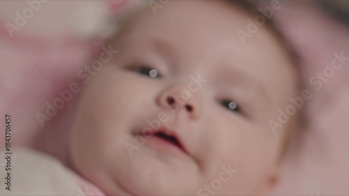 Newborn baby girl smiling in the crib